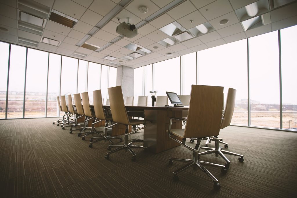 A clean office space with a desk and chairs in a meeting room